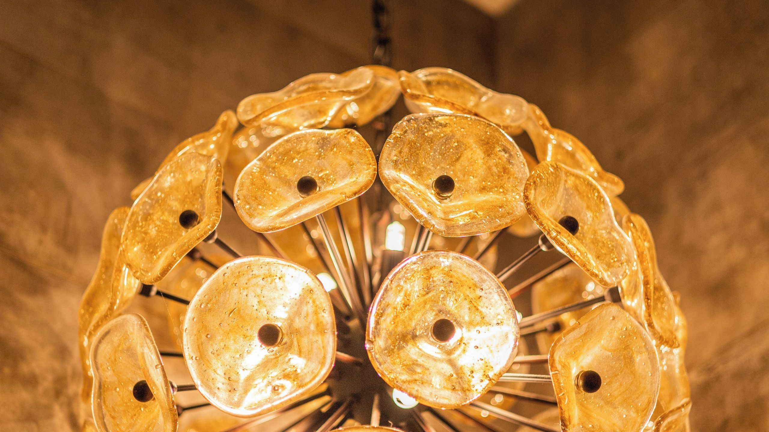 Un lustre composé de plusieurs éléments en verre et de barres métalliques.