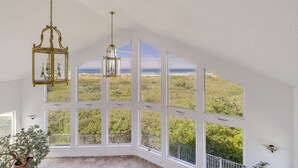 Ein Zimmer mit großen Erkerfenstern und Blick ins Freie.