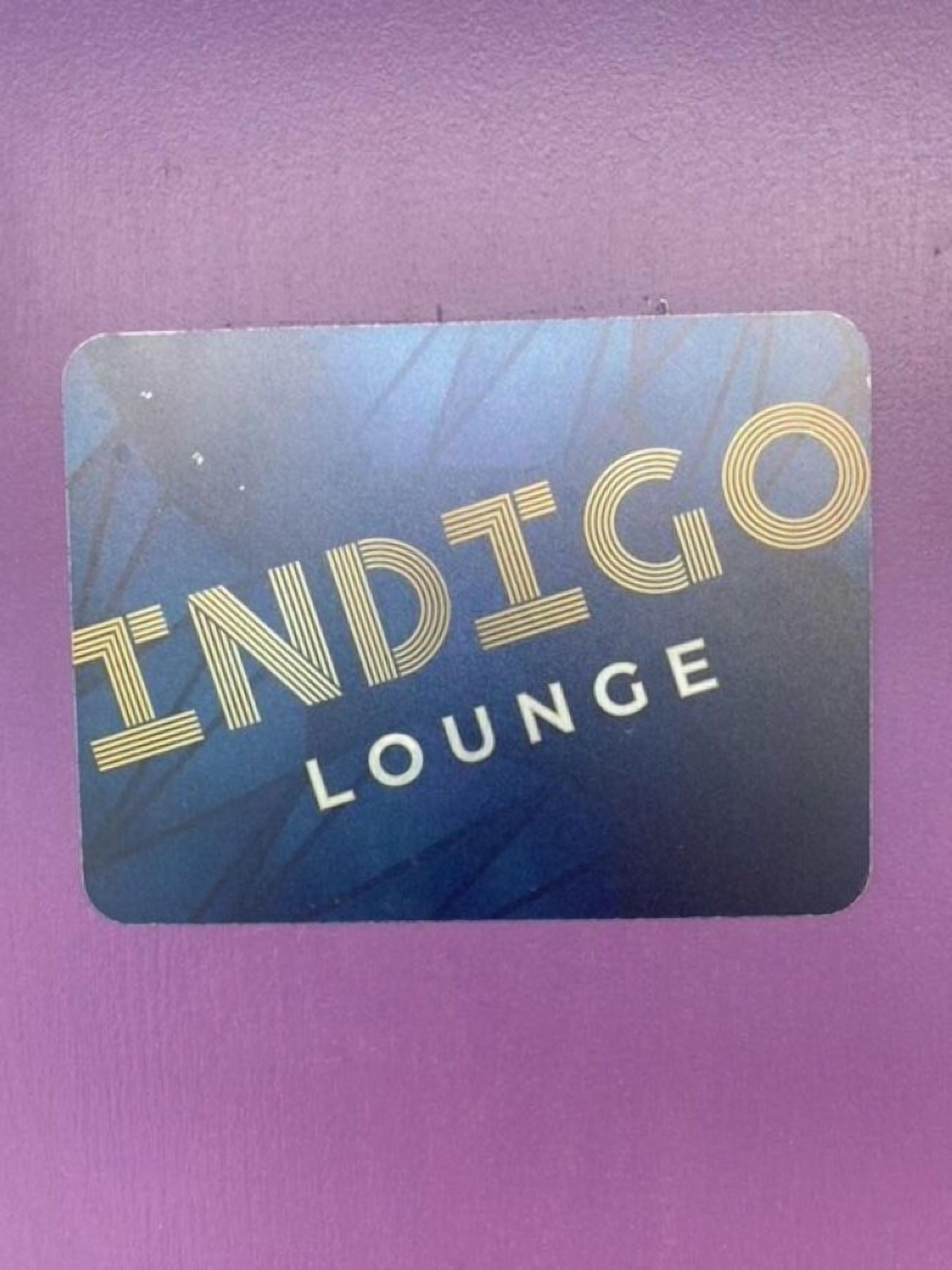A sign with the words "INDIGO LOUNGE" in gold lettering on a blue background.