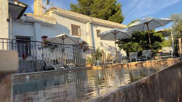 Alberca al aire libre y camastros