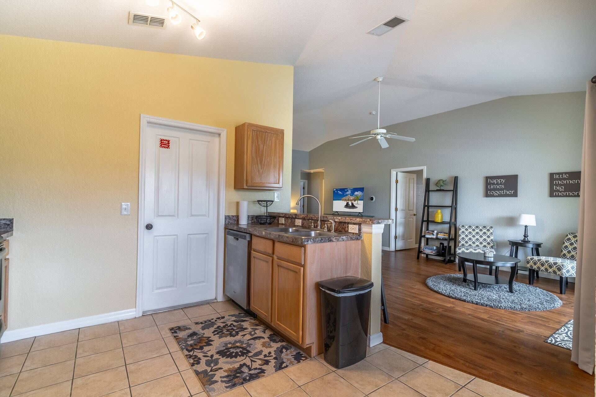 A kitchen with wooden cabinets, a built-in dishwasher, and a granite countertop.