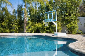 Una piscina con aro de baloncesto.