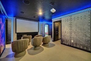 Relax in a spacious room with a large flat-screen TV, plush seating area, and industrial-style decor.