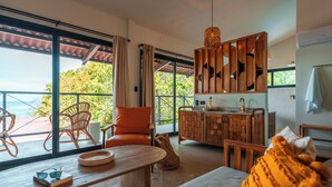 Un amplio salón con un gran ventanal, un armario de madera y una zona de estar acogedora.