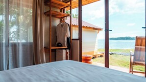 Un dormitorio con una cama grande, un armario de madera y vistas al mar.