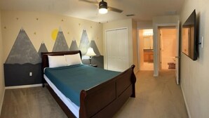 A bedroom with a bed, a ceiling fan, a nightstand, a lamp, and a wall with a mountain-themed mural. - New Listing! Silver Creek Resort, 4mi to Disney & 13mi to Universal - FS376683 (Clermont)