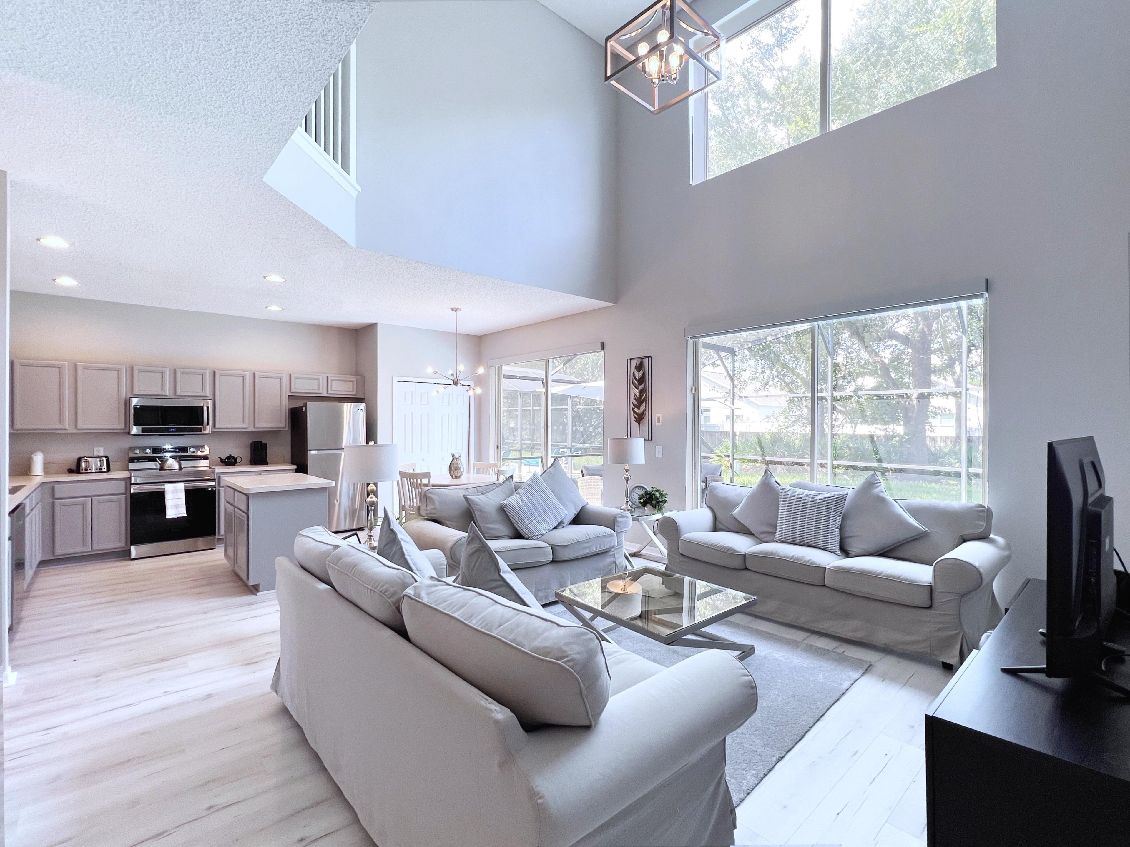 A spacious living area with a kitchen, large windows, and a modern design.