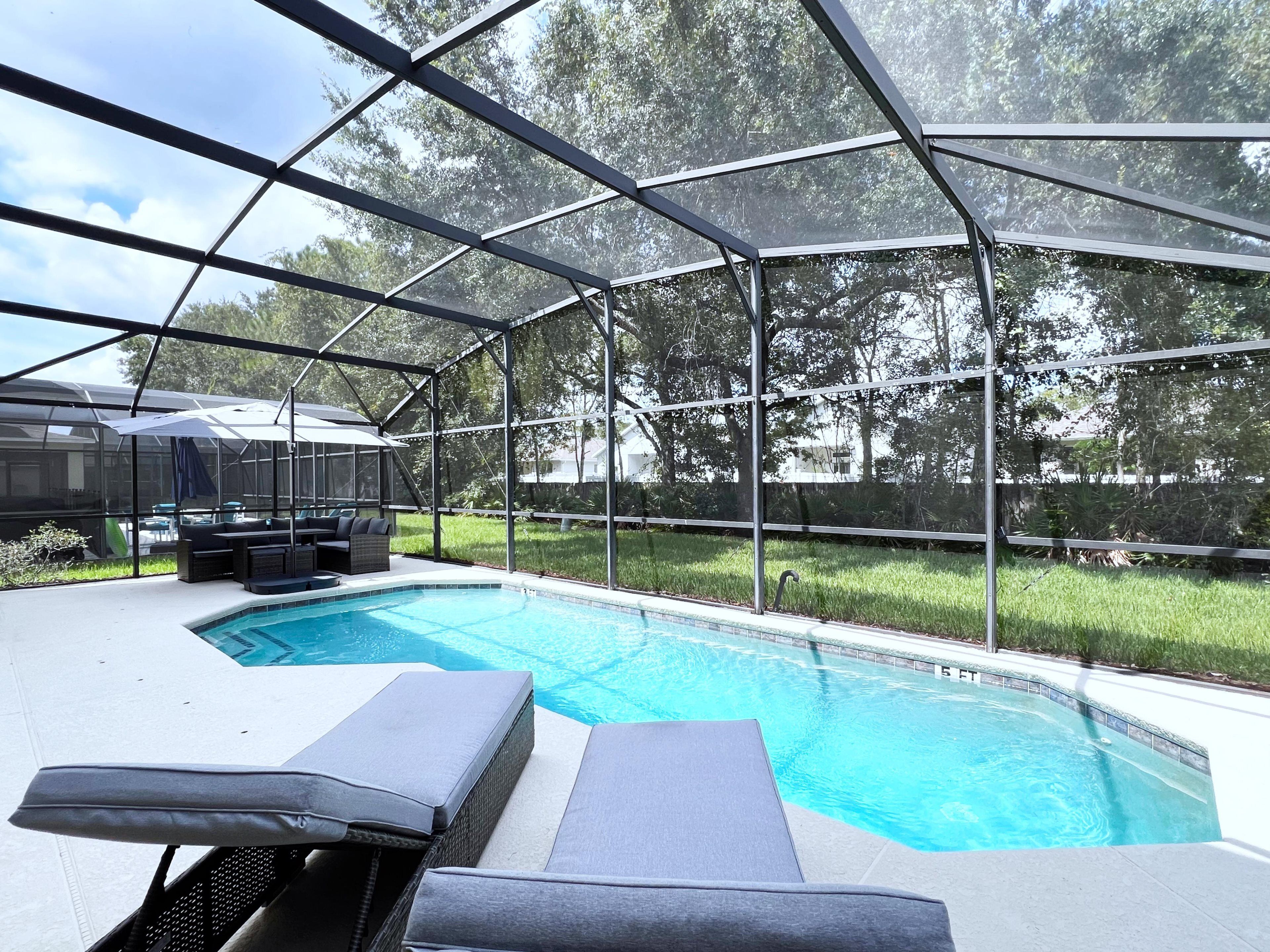 Una piscina cubierta al aire libre con sillones de descanso y un área de patio.