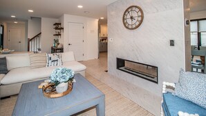 A modern living room with a sofa, coffee table, and a fireplace. - Spacious 4BR with rooftop deck – ocean views & beach access (Seaside Heights)