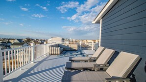 A balcony with sun loungers and a view of the neighborhood. - Spacious 4BR with rooftop deck – ocean views & beach access (Seaside Heights)