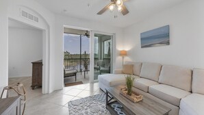 A living room with a sofa, a coffee table, a lamp, and a view of the outdoors through a glass door. - New Listing! Charlotte Harbor Area Resort, 120mi to Disney & 134mi to Universal - GRH598410 (Punta Gorda)