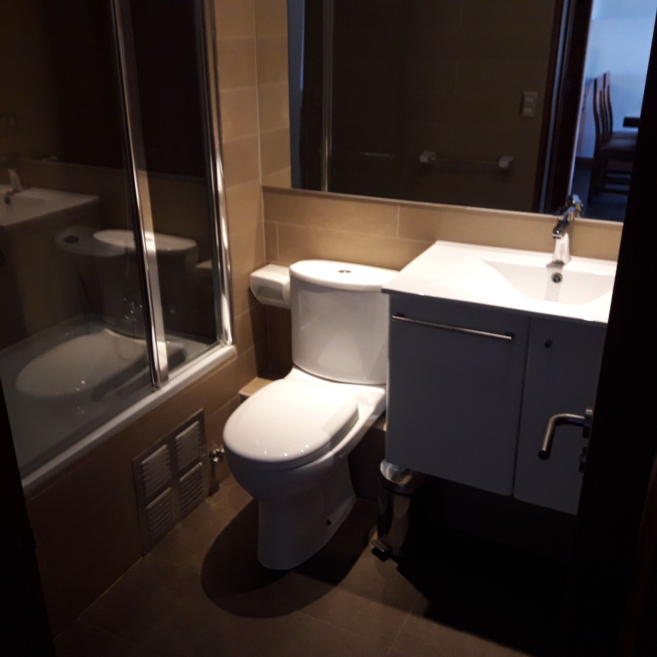 Een badkamer met toilet, wastafel en douche.