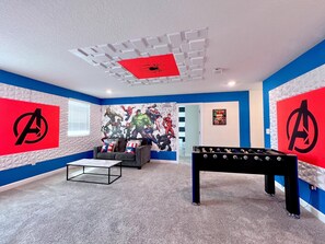 Relax in a vibrant space with a unique mural, comfortable seating area, and foosball table.