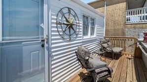 A mobile home with a deck, a large clock, and outdoor seating. - Oceanfront Escape Just Steps to Beach & Boardwalk , beach badges 2 car park (Seaside Heights)