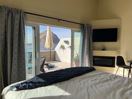 Un dormitorio con cama, televisión, escritorio y silla.