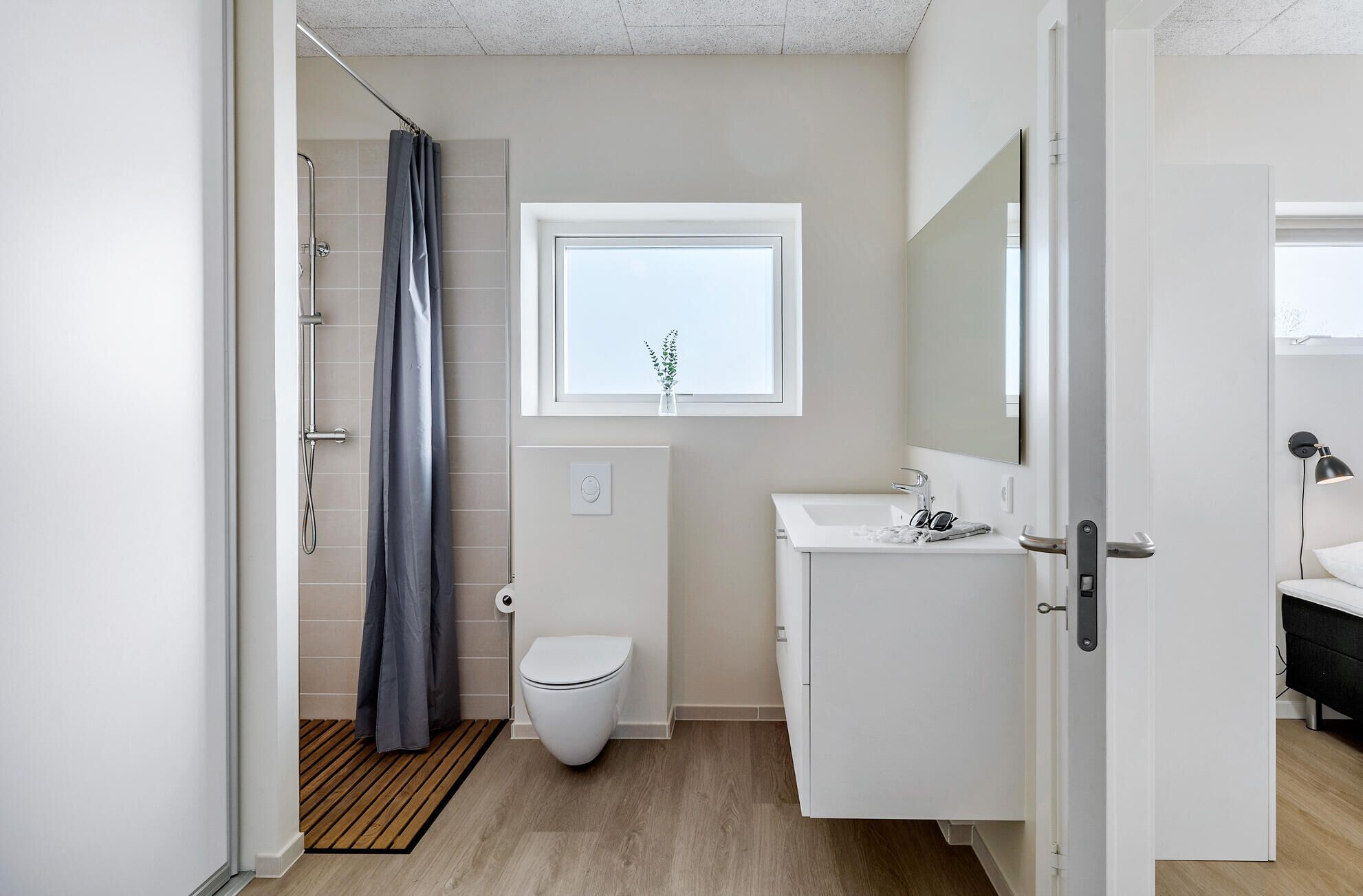 A modern bathroom with a shower, toilet, and sink.