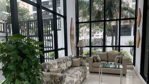 Una sala moderna con un sofá, una mesa de centro de vidrio y una planta en maceta.