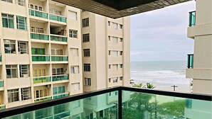 Un edificio alto con múltiples balcones que dan a la vista del litoral.