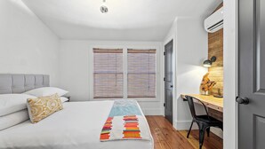 A bedroom with a bed, a desk, and a chair. - Luxury 3 Bedroom House with Airstream, Cabin, Private Fireplace, and Plunge Pool (Comfort)