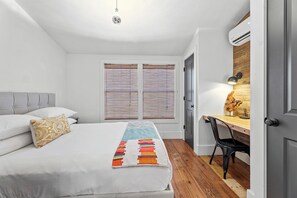 Una camera da letto con un letto, una scrivania e una sedia.