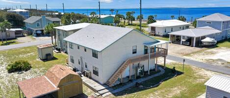 A coastal residential area with houses, a covered garage, and a view of the ocean.