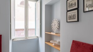 A room with a window, a red couch, and two framed pictures on the wall. - iFlat | Lovely in Trevi Fons Trevi II (Roma)