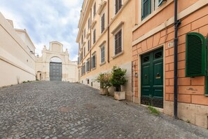 Une rue pavée bordée de bâtiments historiques, avec une porte et une porte verte.