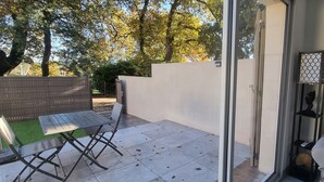 Een terras met een tafel, stoelen, een bank en een decoratieve lamp.