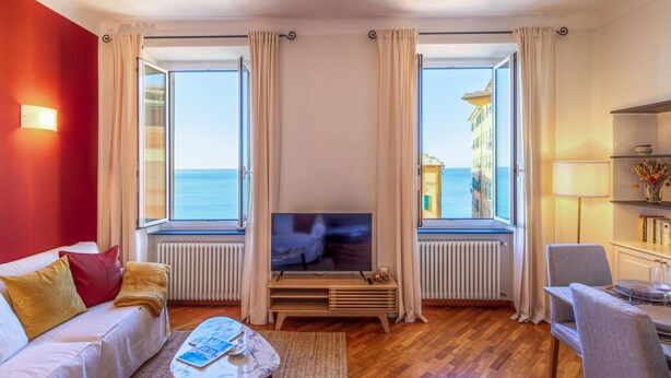 A living room with a TV, sofa, and a view of the sea. - 🏠 PROPERTY DESCRIPTIONCasa Valentina is located in a typical Ligurian building, in a central area near the charming harbor of Camogli.It is the perfect starting point for a seaside holiday without the need to use a car or public transport.In just 5 mi (Camogli)
