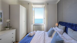 A bedroom with a bed, a dresser, a window with curtains, and a view of the sea. - 🏠 PROPERTY DESCRIPTIONCasa Valentina is located in a typical Ligurian building, in a central area near the charming harbor of Camogli.It is the perfect starting point for a seaside holiday without the need to use a car or public transport.In just 5 mi (Camogli)