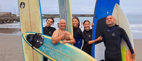 Un grupo de personas sosteniendo tablas de surf en una playa.