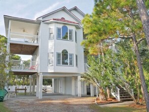 A two-story house with a balcony on the upper floor, a front porch, and a staircase leading to the upper level.