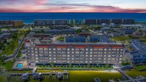 Un hotel con varios pisos, piscina y un puerto deportivo.