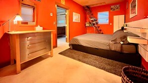 A bedroom with a bed, dresser, and a ladder leading to a loft. - Joe's Bike Shop w/ Garage and EV Charging (Flagstaff)