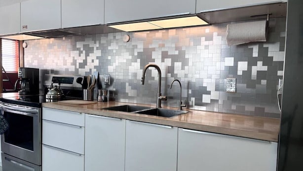 A modern kitchen with a stainless steel range hood, double sink, and white cabinetry. - Joe's Bike Shop w/ Garage and EV Charging (Flagstaff)