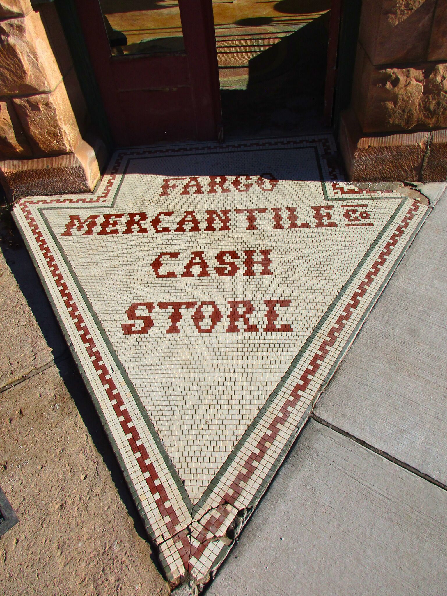 Ingresso di un negozio caratterizzato da piastrelle a mosaico e con la scritta "FARCO MERCANTILES CASH STORE".