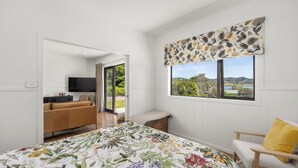 Un dormitorio con una cama grande, un sofá, un televisor y una ventana con vistas al exterior.