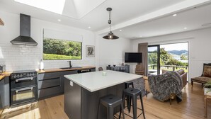 Una cocina moderna con una isla grande, horno empotrado y vistas al exterior.
