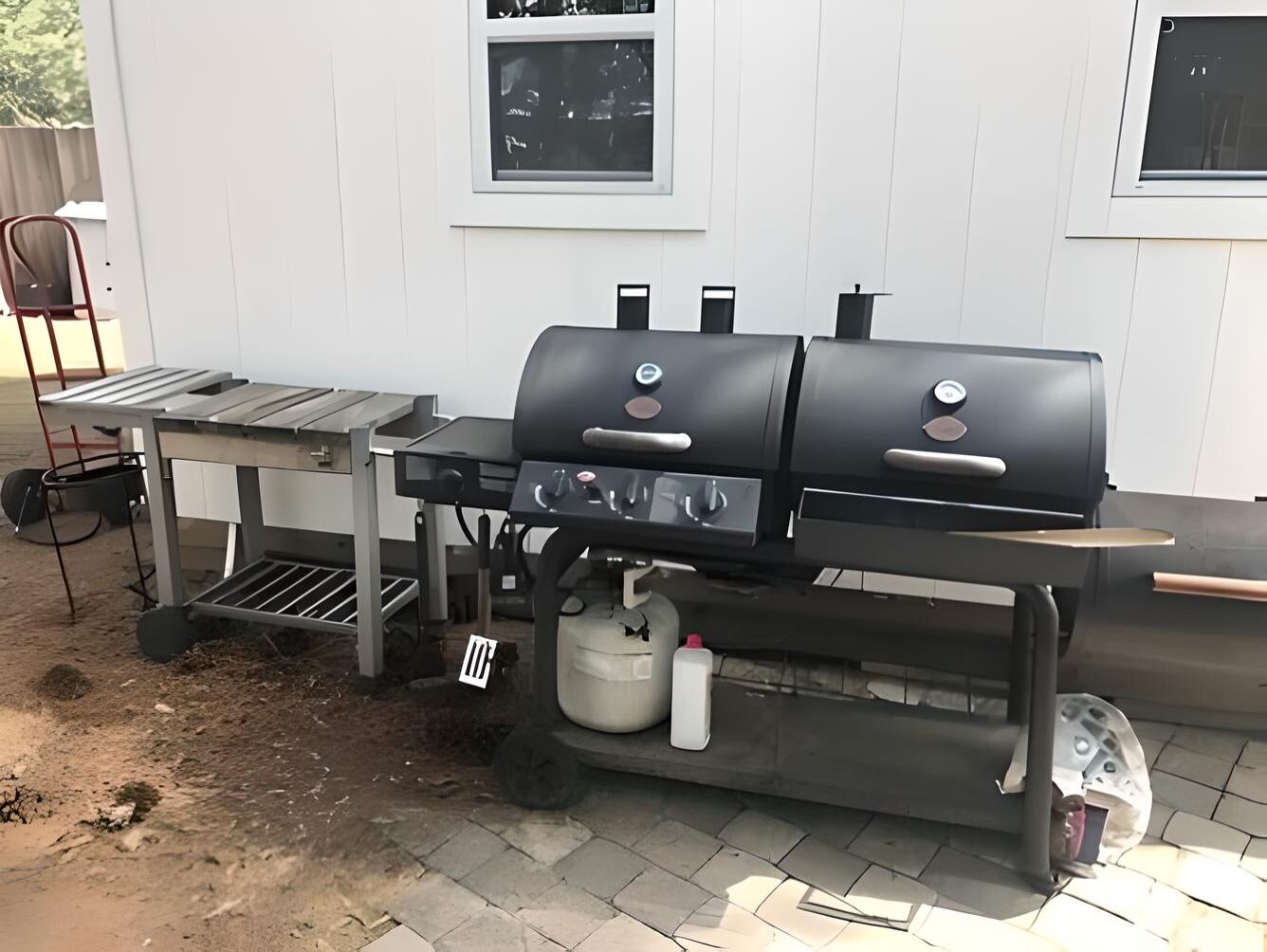 A portable grill setup with a table and a gas tank.