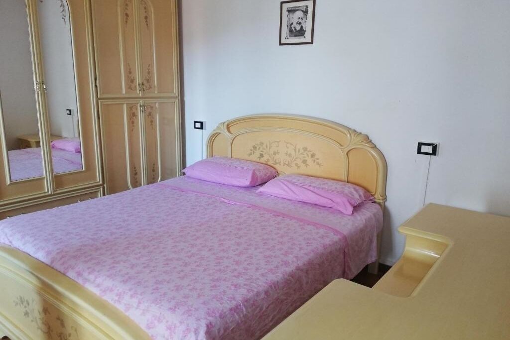 Ein Schlafzimmer mit einem Bett, einem Schminktisch und einem Spiegel.