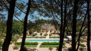 A pool area with a clear view of the surrounding landscape, including trees and a building in the background.