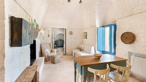 A rustic interior with a wooden table, chairs, a bench, and a blue door.
