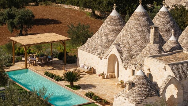 A villa with a swimming pool, outdoor seating, and stone-roofed buildings. - Trullo Pia - Trullo with private pool (Monopoli)
