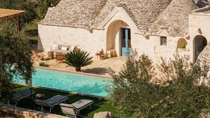 A stone house with a swimming pool, outdoor seating, and a garden. - Trullo Pia - Trullo with private pool (Monopoli)