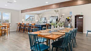 A spacious kitchen with modern appliances, a dining area with blue chairs, and a view of the outdoors. - Luxury Waterfront Retreat: Pool, Fishing & 5BR, Sleeps 12 (Rockport)