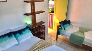 Habitación de hotel con dos camas, un estante de madera, una lámpara verde y vista al exterior.