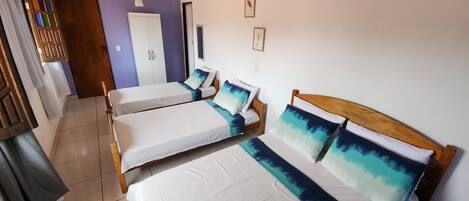 A hotel room with two single beds, a ceiling fan, and a wooden ceiling.