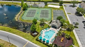 Luftaufnahme einer Wohngegend mit Tennisplatz, Schwimmbad und Basketballplatz.