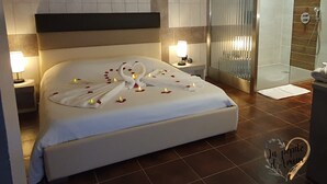 Une chambre d’hôtel comprenant un lit, deux lampes de chevet, une douche et un élément décoratif mural.