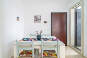A dining area with a table, chairs, and a door.